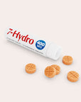 A white tube labeled 7-Hydro 400 MG lies open, with five round, orange chewable tablets spilled out on a light background. The tablets have a cross pattern on top.