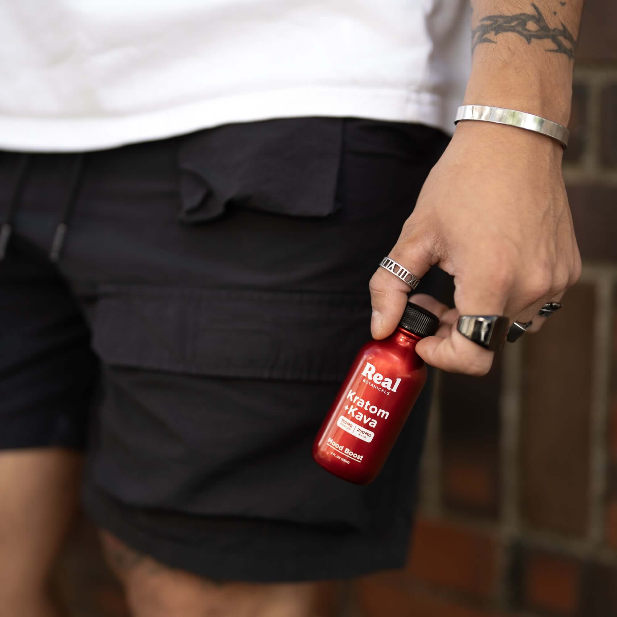 Man holding Kratom and Kava bottle