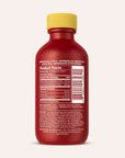 A red bottle of Real Botanicals Kratom Shot with a yellow cap displays product facts, ingredients, and manufacturer information on the back label.