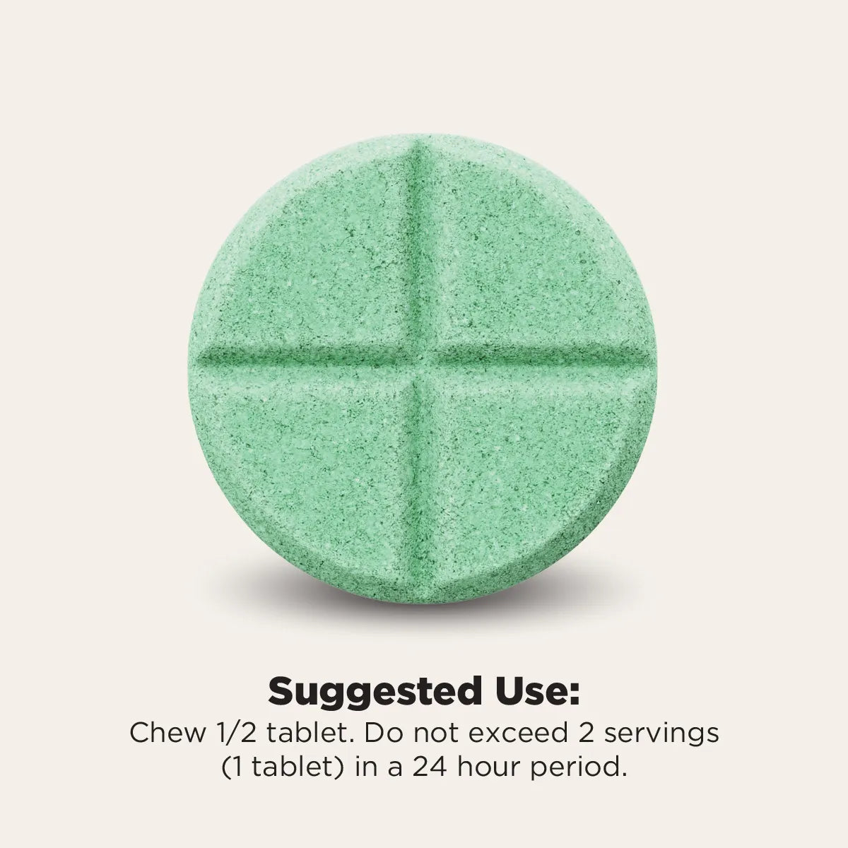 A single round mint-green tablet with a cross-shaped embossing, shown on a light beige background with text below reading 'Suggested Use: Chew 1/2 tablet. Do not exceed 2 servings (1 tablet) in a 24 hour period.